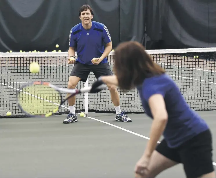  ?? ED KAISER ?? Ivan Quintero, a coach and tennis pro at the Saville Sports Centre, works with reporter Liane Faulder as she looks to improve her fledgling tennis game.