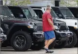  ?? AP PHOTO/DAVID
ZALUBOWSKI ?? In this April 26 photo, a prospectiv­e buyer looks over a row of unsold 2020 Wranglers at a Jeep dealership.