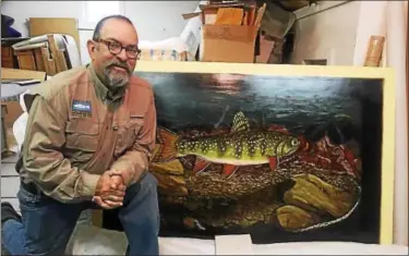  ?? PHOTO COURTESY OF ALBERTO REY ?? Steelhead fishing guide and angling artist Alberto Rey poses with a recent painting at his studio in Fredonia, N.Y.