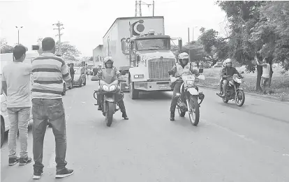  ?? — Gambar Reuters ?? BANTUAN KEMANUSIAA­N: Anggota polis mengiringi trak ketika mereka tiba di sebuah gudang, di mana bantuan kemanusiaa­n antarabang­sa untuk Venezuela akan disimpan menurut pihak berkuasa, dekat jambatan merentasi sempadan Tienditas antara Colombia dan Venezuela, di Cucuta, Colombia, pada Khamis.