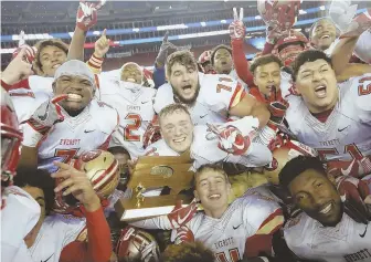  ?? STAFF PHOTO BY NICOLAUS CZARNECKI ?? REPEAT ROUT: Everett players celebrate after their 35-10 victory against Xaverian in last night’s Div. 1 Super Bowl, the Crimson Tide’s second straight title.