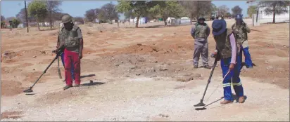  ??  ?? Diligence… Members of the explosive unit comb the ground for possible ammunition.