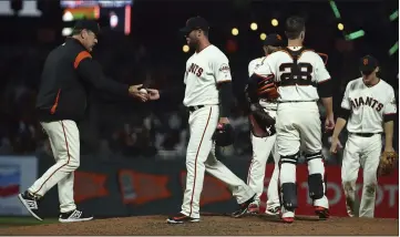 ?? BEN MARGOT — THE ASSOCIATED PRESS ?? Manager Bruce Bochy, left, relieves Hunter Strickland on Monday night. Things didn’t go well after that for Strickland.
