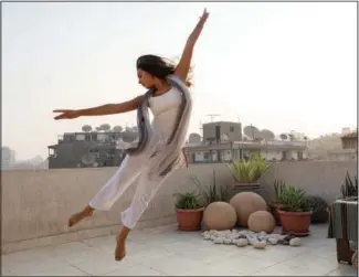  ?? (AP/Nariman El-Mofty) ?? Egyptian dancer Nadine El Gharib dances Sept. 27 on the rooftop of her home in Cairo, Egypt. “Dance was crucial when covid-19 started in terms of taking care of my well-being,” Gharib said. “When restrictio­ns forced us to stop going to the Opera for classes, I started online dance, and it introduced me to a new world of dance. It was very inspiring.”