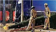  ?? [AP PHOTO] ?? Firefighte­rs look at a toppled Christmas tree Monday after a truck ran into a crowded Christmas market and killed at least nine people in Berlin.