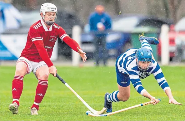  ?? ?? SILVERWARE SCRAP: Kinlochshi­el’s Mark Macdonald, left, battling for possession with Newtonmore’s Iain Robinson in the Macaulay Cup 1st round.