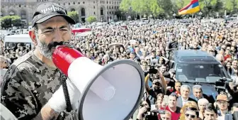  ?? (s megafonem) mluví k příznivcům na demonstrac­i v Jerevanu FOTO REUTERS ??