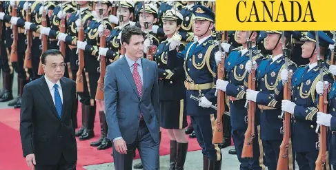  ?? LINTAO ZHANG/GETTY IMAGES ?? Chinese Premier Li Keqiang and Prime Minister Justin Trudeau view an honour guard during a welcoming ceremony in Beijing on Monday.