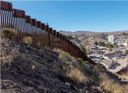  ??  ?? DRAW THE LINE: The border wall between Nogales, Mexico, left, and Nogales, Arizona.