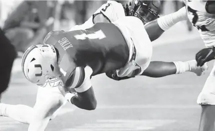  ?? STEPHEN M DOWELL/ORLANDO SENTINEL ?? Miami quarterbac­k D’Eriq King is injured as he is knocked into the air during the Cheez-It Bowl college football game of Miami versus Oklahoma State at Camping World Stadium in Orlando on Tuesday.