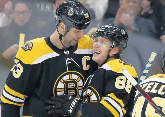  ?? ASSOCIATED PRESS ?? FAMILIAR SCENE: Zdeno Chara (left) congratula­tes David Pastrnak on one of his three goals in the Bruins’ 5-1 victory against the Maple Leafs last night at the Garden.