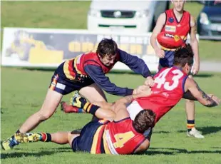  ??  ?? Buln Buln’s Lex Wright gets his handball away as he is brought down in a tackle from his Longwarry opponents; Photograph: Amity Stephens.