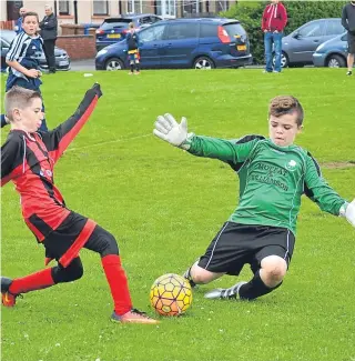  ??  ?? Dundee Thistle’s goalkeeper closes down a Douglas striker in their well-contested Age 11 clash at Claypotts.