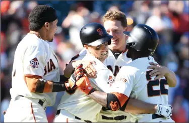  ?? DOUG DURAN/TRIBUNE NEWS SERVICE ?? The Giants' Buster Posey, second from left, celebrates with, from left, Gorkys Hernandez, Nick Hundley and Andrew McCutchen after driving in the winning run in the 13th inning against the Chicago Cubs in San Francisco on Wednesday.