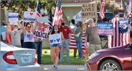  ?? Dan Watson/The Signal ?? Demonstrat­ors hold signs at a Blue Lives Matter rally Friday as cars pass the intersecti­on of Magic Mountain Parkway and Valencia Boulevard in Valencia.