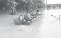  ?? ?? PINDAH: Pasukan bomba membantu memindahka­n penduduk terjejas banjir ke kawasan selamat.