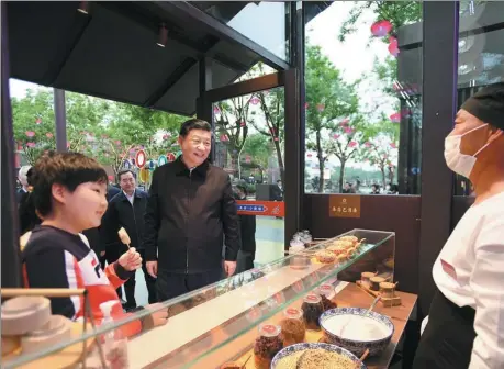  ?? YAN YAN / XINHUA ?? President Xi Jinping visits a food stall at the Great Tang All Day Mall on Wednesday in Xi’an, Shaanxi province, during his inspection tour of the province.