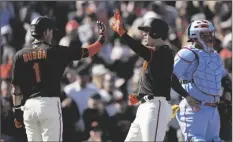  ?? TONY AVELAR/AP ?? SAN FRANCISCO GIANTS’ WILMER FLORES (RIGHT) is congratula­ted by Mauricio Dubon (1) as he crosses home plate after hitting a grand slam against the St. Louis Cardinals during the first inning of a game on Saturday in San Francisco.