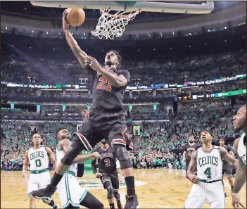  ??  ?? Chicago forward Jimmy Butler (21) drives to the basket through Boston’s defense in the first quarter of Tuesday’s game in Boston. The Bulls won 111-97 against the Celtics.