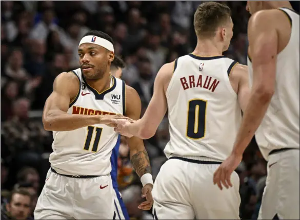  ?? AARON ONTIVEROZ — THE DENVER POST ?? The Nuggets’ Bruce Brown, left, hypes up Christian Braun after Braun’s layup against the Golden State Warriors last month at Ball Arena.