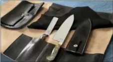  ?? RICHARD DREW — THE ASSOCIATED PRESS ?? The Town Cutler Chef Kit, that consists of their Black Leather 5-Slot Knife Wrap, an 8.5-inch AEB-L Stainless Steel Chef Knife with Buckeye Burl Handle and leather scabbard, right, and a 4-inch Charcoal Palette Knife, is shown.