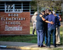  ?? THE NEW YORK TIMES FILE ?? Men pray outside Robb Elementary School in Uvalde, Texas, on May 25. the day after 19 children and two teachers were killed by an 18-year-old gunman’s rampage.