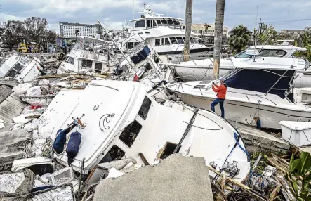  ?? PHOTO: TNS ?? Aftermath . . . A man takes photos of boats damaged by Hurricane Ian in Fort Myers, Florida, yesterday.