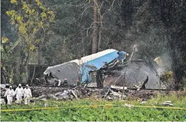  ?? [AP PHOTO] ?? Forensic investigat­ors and Ministry of Interior officers sift through remains of a Boeing 737 that plummeted into a yuca field with more than 100 passengers on board, Friday in Havana, Cuba.