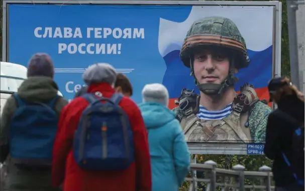  ?? ?? En plakat foran et busstoppes­ted i Skt. Petersborg viser Sergej Tsjerkovni­j, vaerneplig­tig i den russiske haer, og budskabet »AEret vaere Ruslands helte!« Foto: Reuters/Anton Vaganov