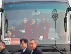  ?? HOW HWEE YOUNG, EUROPEAN PRESSPHOTO AGENCY ?? Flight attendants wait aboard a bus in March in Beijing. The new female-only bus service is getting mixed reviews.