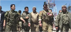  ?? (Rodi Said/Reuters) ?? A US military commander (second right) walks with Kurdish fighters at YPG headquarte­rs, which was hit by Turkish air strikes yesterday.