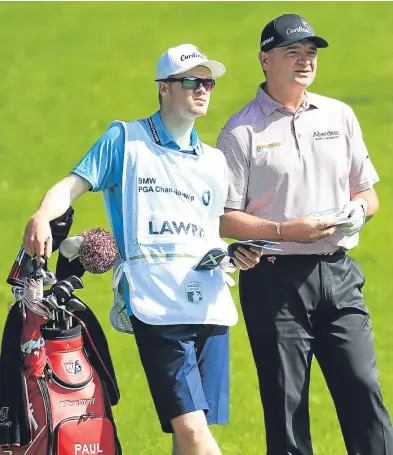  ?? Getty. ?? Paul Lawrie and son Michael on the fairway during the opening day of the BMW PGA.