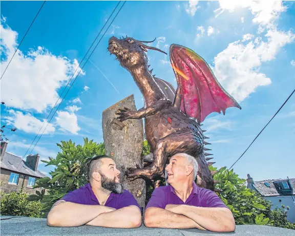  ?? Picture: Steve MacDougall. ?? Kyran Thomas and his father Rory with Fiona’s Dragon, which is proving a popular addition to the village of Limekilns.