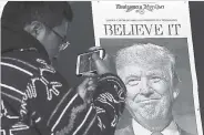  ?? AP ?? Zheng Gao of Shanghai, China, photograph­s the front pages of newspapers on display outside the Newseum in Washington on November 9, the day after Donald Trump won the presidency.