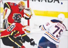  ?? Canadian Press photo ?? Edmonton Oilers' Evan Bouchard, right, scores on Calgary Flames goalie David Rittich, from the Czech Republic, during first period preseason NHL hockey action in Calgary, Monday.
