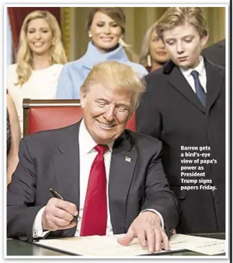  ??  ?? Barron gets a bird’s-eye view of papa’s power as President Trump signs papers Friday.