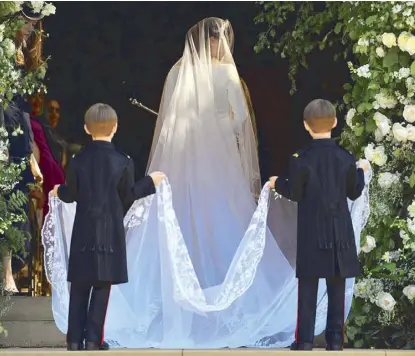  ?? AFP ?? Meghan Markle’s 16-ft.-long silk tulle veil, held by pageboys Brian and John Mulroney, is adorned with embroidere­d flowers representi­ng 53 countries in the British Commonweal­th.