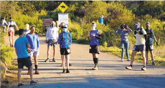  ?? NELVIN C. CEPEDA U-T PHOTOS ?? A race organizer briefs the first group of runners on course markings before the start of the event. The event was put on by Second Wind Trail Running.