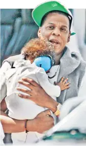  ??  ?? Jay-Z Blue Ivy Carter, protects his 8-month-old baby girl,
by covering her ears with noise blockers as they arrive in New York City by — how else? — helicopter yesterday.