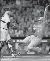  ?? Bob Levey Getty Images ?? MARTIN MALDONADO slides home on an infield hit in the third inning to give the Angels a 3-1 lead.