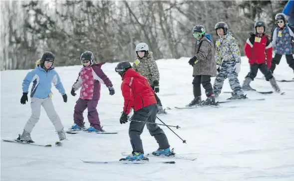  ?? JOHN LUCAS/EDMONTON JOURNAL ?? Ski instructor Dave Morris, foreground, leads a group of beginners down the hill at the Snow Valley Ski Club on Monday.