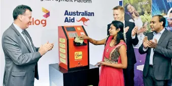  ??  ?? From left: The first ez Cash transactio­n on the ATM takes place by Dialog customer, Shiroshini Maximin at the Jaffna Branch, whilst Bryce Hutchesson, Australian High Commission­er to Sri Lanka, Dr. R Rainer Deutschman­n, Chief Operating Officer of Dialog...