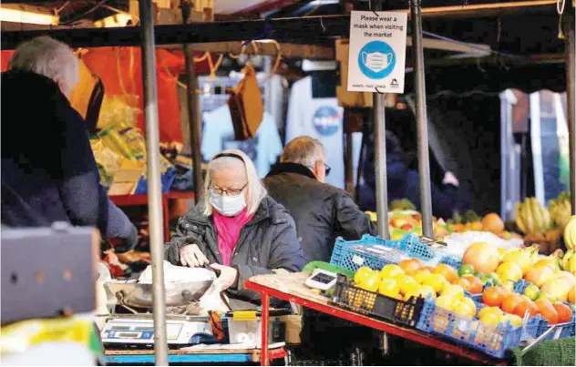  ?? Reuters ?? A woman shops in Cambridge Market Square in Cambridge, Britain.