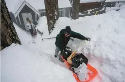  ?? JAE C. HONG/AP ?? Angie Gourirand backs down the snow-covered steps to her home with groceries on a sled Tuesday in Running Springs, in California’s San Bernardino County.