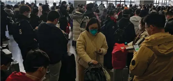  ?? ?? Travellers wearing face mask gather at a departure hall as they prepare to catch their trains at the West Railway Station in Beijing, yesterday. Photo: AP/Andy Wong.