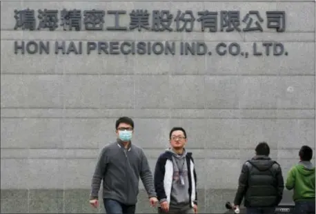  ?? WALLY SANTANA — THE ASSOCIATED PRESS FILE ?? In this file photo, employees enter and Foxconn, in New Taipei City, Taiwan. exit the headquarte­rs of Taiwan’s Hon Hai Precision Industry Co., also known as