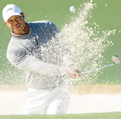  ?? WARREN LITTLE/GETTY ?? Tiger Woods plays a shot from a bunker during the continuati­on of the first round of the Masters on Friday at Augusta National Golf Club in Augusta, Georgia.