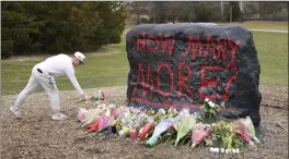  ?? PAUL SANCYA — THE ASSOCIATED PRESS ?? A student leaves flowers at The Rock on the grounds of Michigan State University, in East Lansing, Mich., Tuesday. A gunman killed several people and wounded others at the university Monday night. Police said the shooter eventually killed himself.