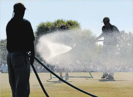  ?? THE ASSOCIATED PRESS ?? In a controvers­ial move, greens staff at the 2004 U.S. Open were forced to hand-water the 7th green in between groups to keep the green ‘playable.’