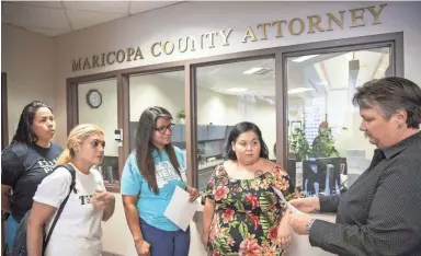  ??  ?? Vangelina Gloria, left, mother of Valentina Gloria; along with Puente Arizona’s lead organizer Maria Castro, center; and its legal director, Jovana Renteria; hand a letter to Maricopa County Attorney Detective Penny Riherd, far right, on Wednesday, asking prosecutor­s to drop charges against the younger Gloria.